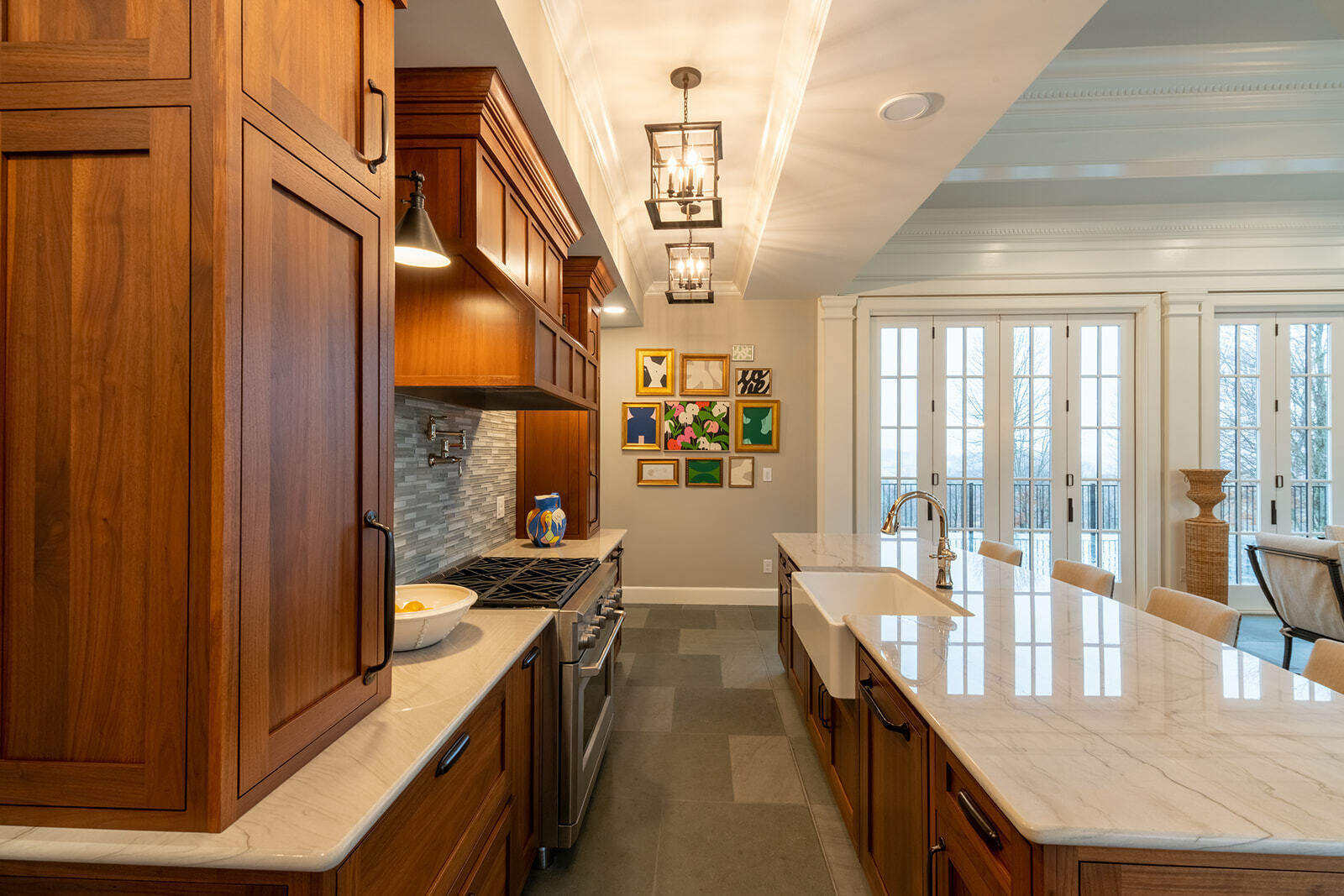A kitchen has stunning wooden cabinets, quartzite countertops and a tile backsplash to create a timeless design.