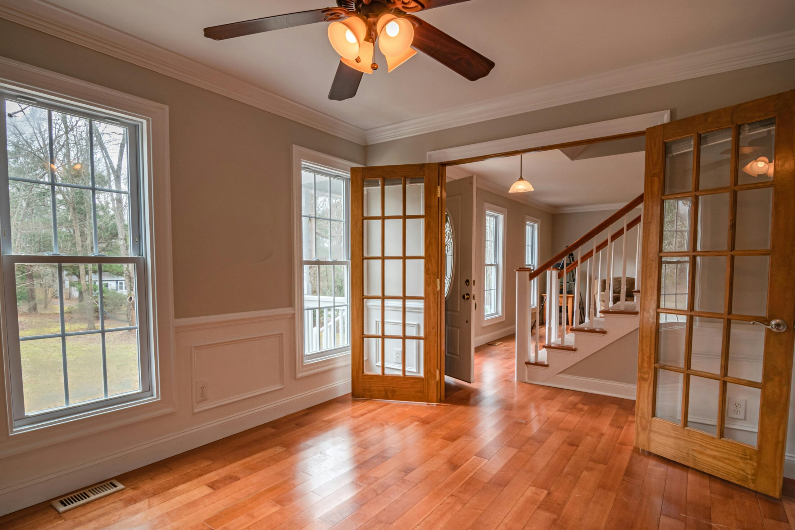 This image depicts a living room with French doors opening to the entryway.