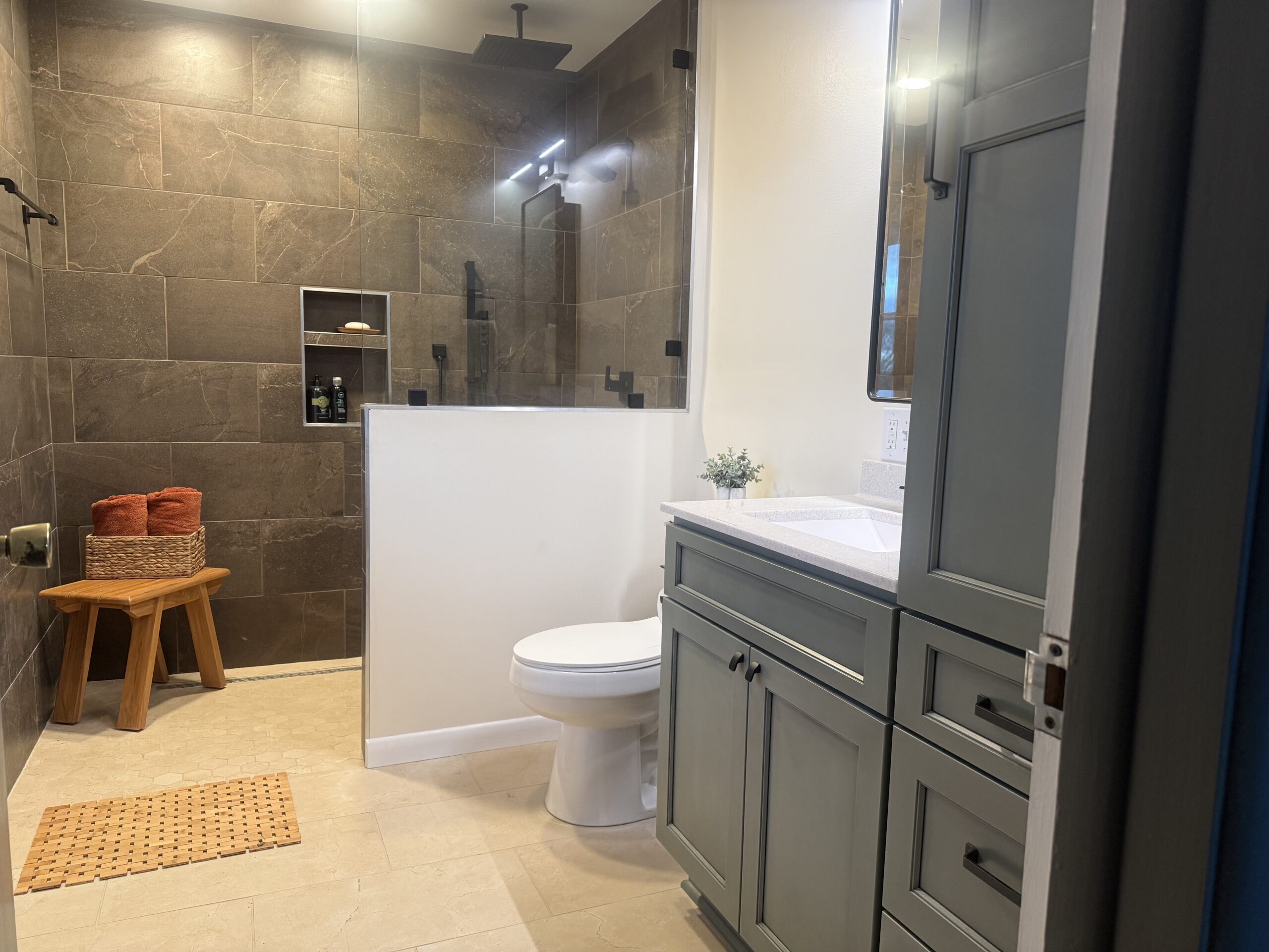 A gray vanity with custom drawers and cabinets offers maximum bathroom storage.