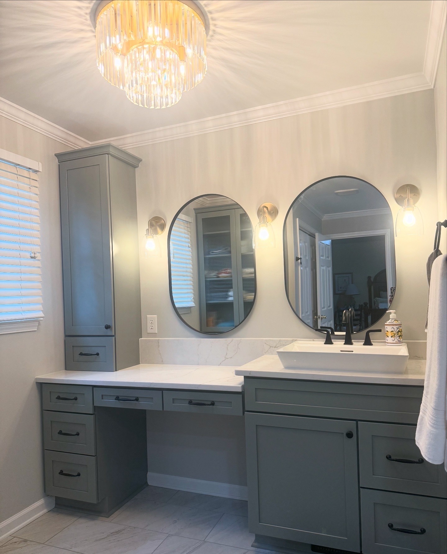 A stylish modern bathroom has custom gray cabinets and black accents.