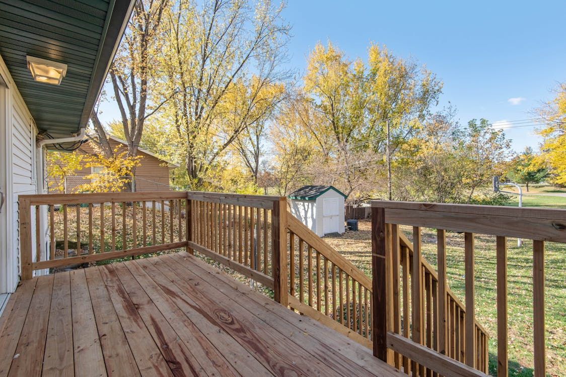 A home has a back deck with pressure-treated wood for long-term strength. Steps lead down to a spacious backyard.