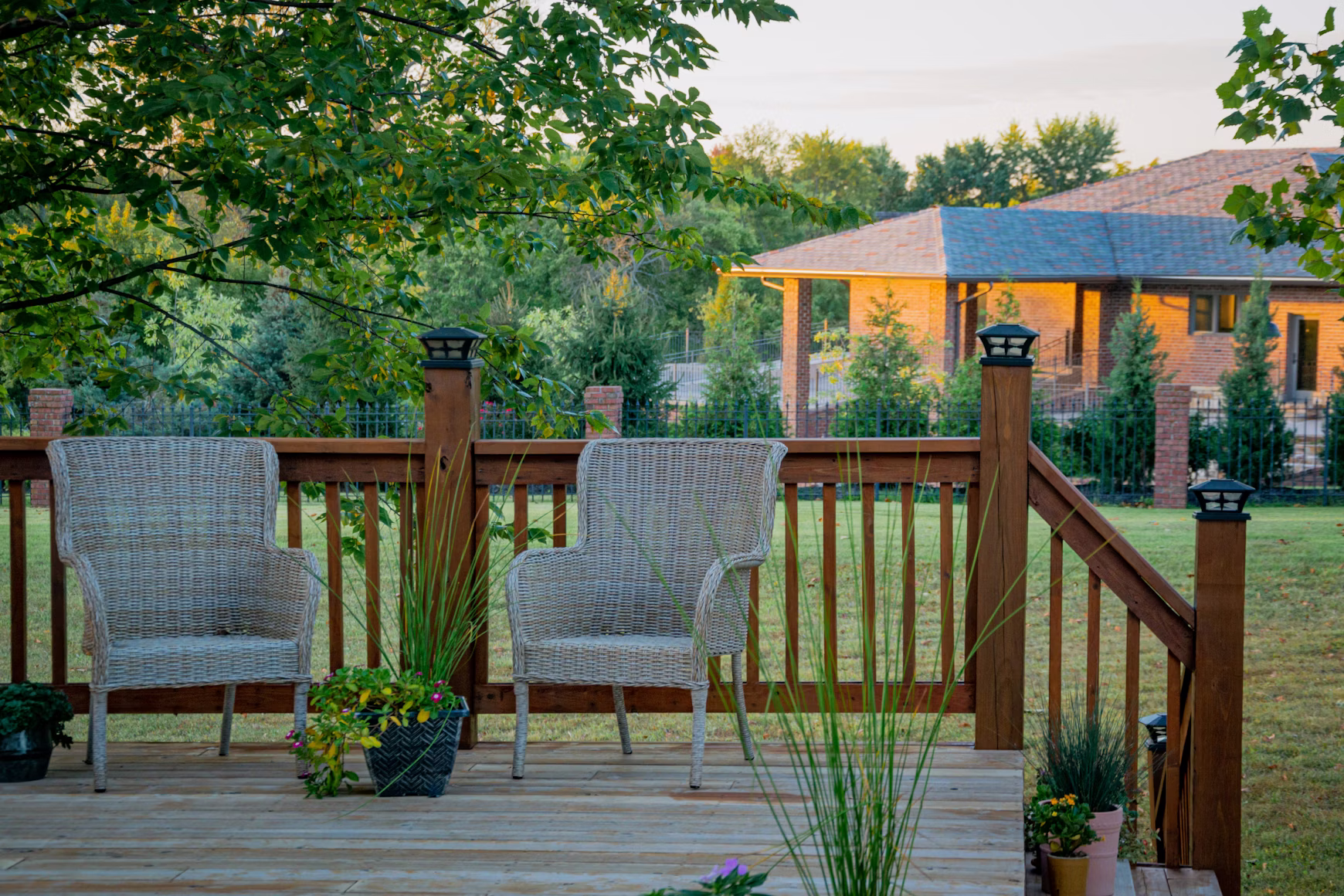 A house has a back deck with pressure-treated wood for long-term strength. Chairs are set on the deck for relaxation.