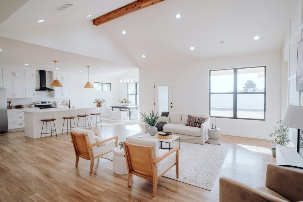 A modern home has a vaulted ceiling in the living room with a visible beam.